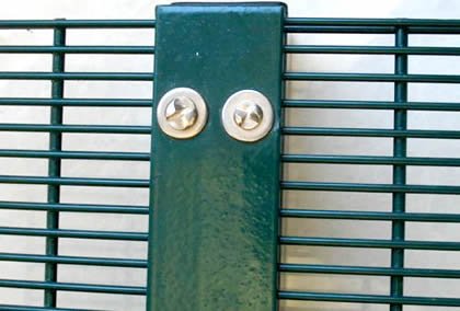 Detail of green 2D welded security fence panel connected to post