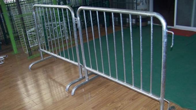 Two connected steel crowd barriers supported by removable bridge feet
