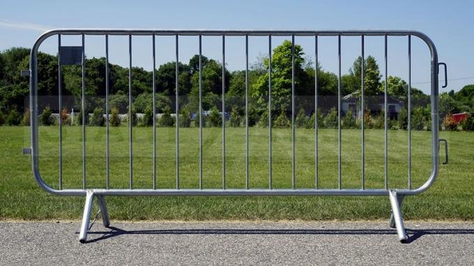 Steel pedestrian barrier standing on concrete with crossed support feet
