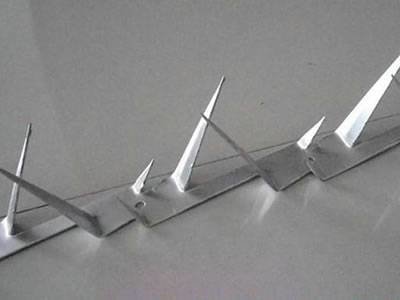 Galvanized steel wall spikes arranged in a row before security fence installation