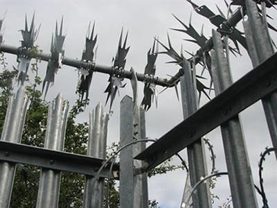 Metal wall spikes mounted above steel palisade security fencing